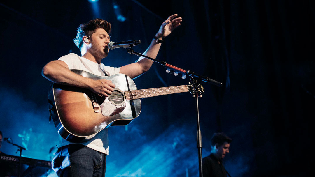 Niall Horan playng with a guitar live